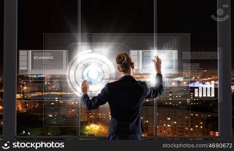 Innovative technologies. Rear view of businesswoman touching icon of media screen