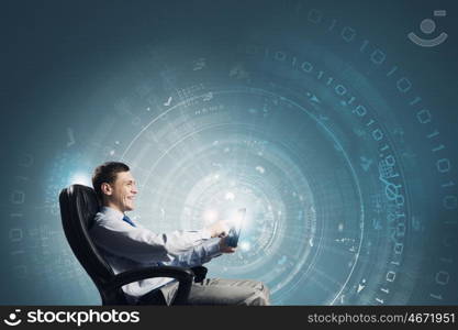 Innovative technologies. Young businessman with tablet in hands against digital background