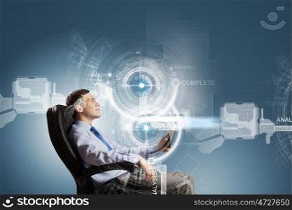 Innovative technologies. Young businessman with tablet in hands against digital background