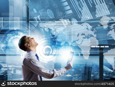 Innovative technologies. Young businessman with tablet in hands against digital background