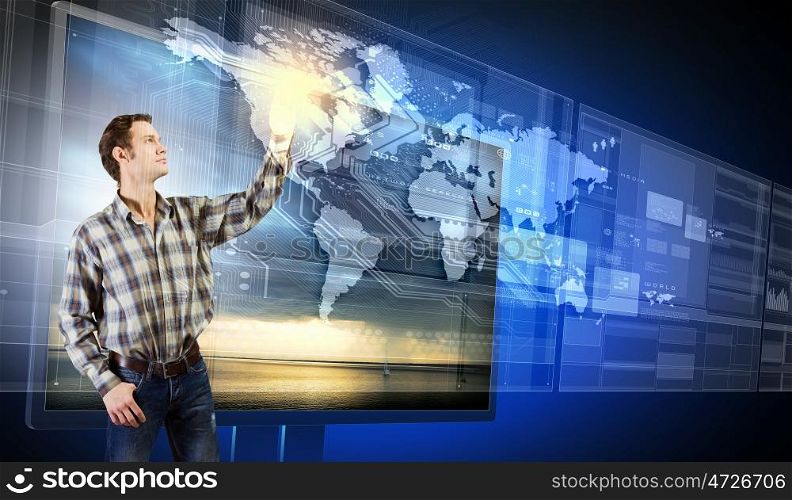 Innovative technologies. Young man in casual touching icon of media screen
