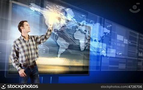 Innovative technologies. Young man in casual touching icon of media screen