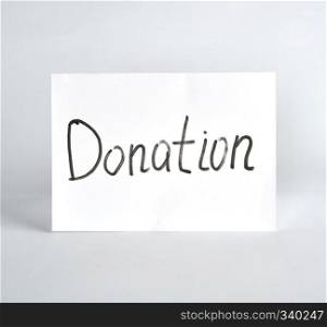 inscription donation  black marker on a white sheet of paper, white background