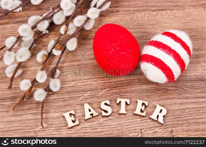Inscription Easter, catkins and eggs wrapped woolen string on rustic board, festive decoration concept. Inscription Easter, catkins and eggs wrapped woolen string on rustic board, festive decoration