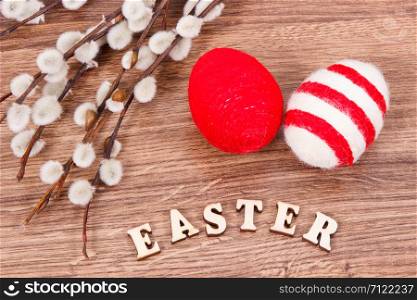 Inscription Easter, catkins and eggs wrapped woolen string on rustic board, festive decoration concept. Inscription Easter, catkins and eggs wrapped woolen string on rustic board, festive decoration