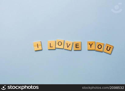 Inscription I love you in wooden letters on a blue background. Ready postcard, banner, place for an inscription. Inscription I love you in wooden letters on a blue background. Ready postcard, banner, place for an inscription.