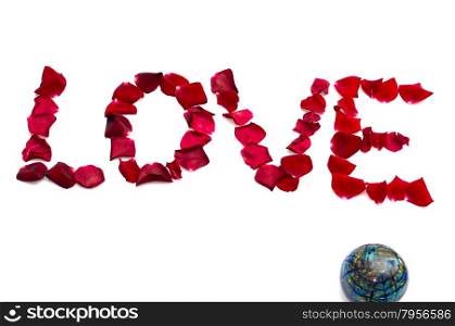 inscription love from petals of roses and nearby the globe