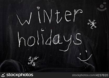 "Inscription "winter holidays", written by a child&rsquo;s hand on the chalk board"