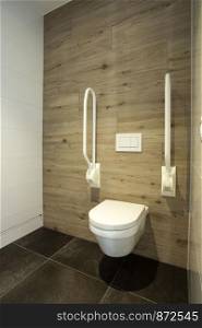 Inside disable toilet. toilet with grab bars for senior or a handicapped person,disable concept. modern design clean and new. Inside disable toilet. toilet with grab bars for senior or a handicapped person,disable concept. modern design