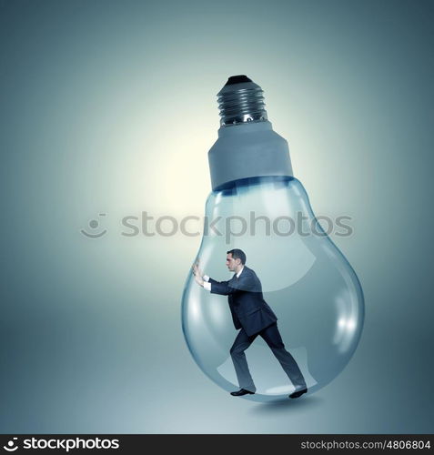 Inside light bulb. Businessman inside light bulb trying to get out