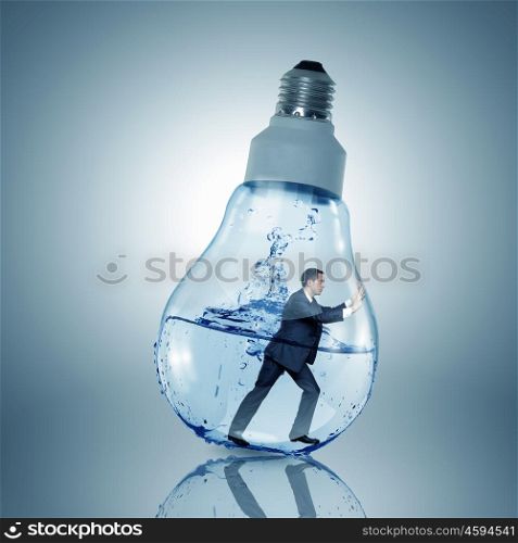 Inside light bulb. Businessman inside light bulb with water trying to get out