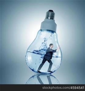 Inside light bulb. Businessman inside light bulb with water trying to get out