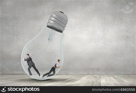 Inside light bulb. Businesswoman and businessman inside light bulb trying to get out