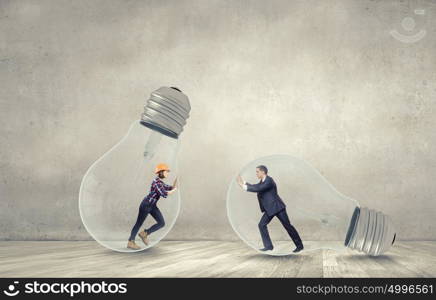 Inside light bulb. Businesswoman and businessman inside light bulb trying to get out