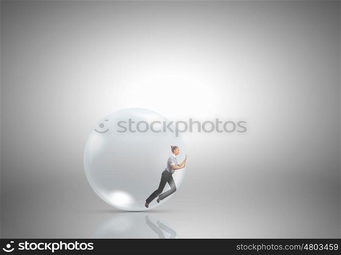 Inside light bulb. Businesswoman inside light bulb trying to get out