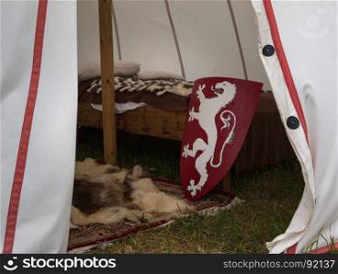 Inside Medieval Tent: Wodden Bed, Carpet and Red Shield with Dragon - Medieval Event Reconstruction