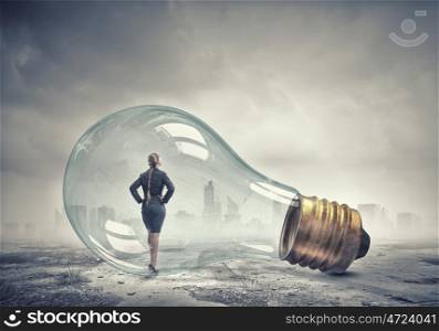 Inside of bulb. Young businesswoman inside of glass light bulb