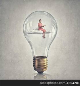 Inside of idea bulb. Young woman sitting on cloud inside of glass light bulb with book in hands