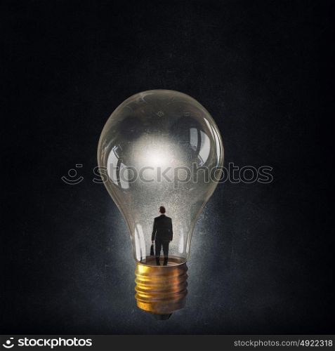 Inside the idea. Rear view of businessman inside light bulb