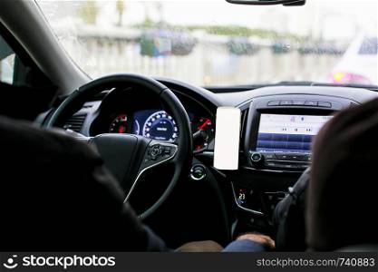 Inside view of the car and mobile phone by the steering wheel, copy space