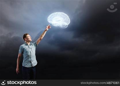 Inspiration concept. Young man and brain illustration against dark background