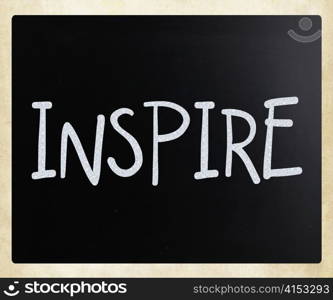 ""Inspire" handwritten with white chalk on a blackboard"