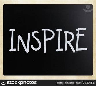 ""Inspire" handwritten with white chalk on a blackboard"