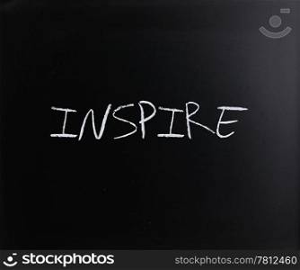 ""Inspire" handwritten with white chalk on a blackboard."