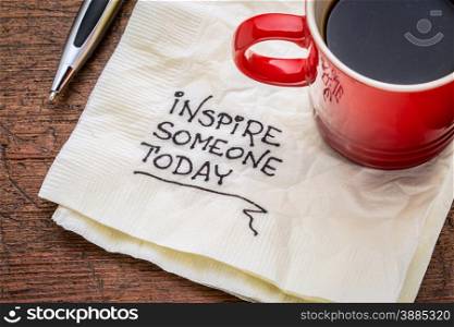 inspire someone today - motivational handwriting on a napkin with cup of coffee