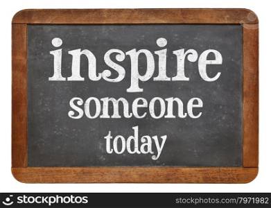 Inspire someone today - motivational phrase on a vintage slate blackboard