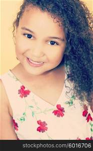 Instagram style filter photograph of a beautiful young mixed race African American girl smiling and looking happy