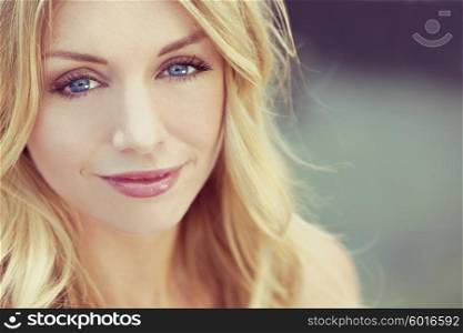 Instagram style portrait of naturally beautiful woman in her twenties with blond hair and blue eyes, shot outside in natural sunlight