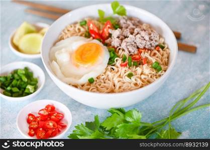 instant noodles cooking tasty eating with bowl, noodles bowl with boiled egg minced pork vegetable spring onion lemon lime lettuce celery and chili on table food, noodle soup - top view