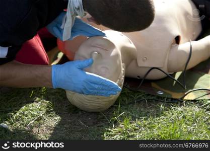 Instructor demonstrates how to check breathing on a dummy