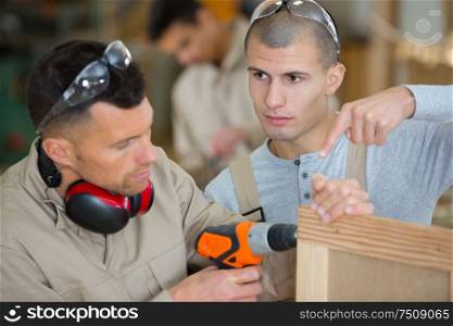 instructor showing trainee joiner how to use drill