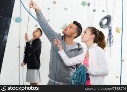 instructor showing young climbers the ropes at indoor wall