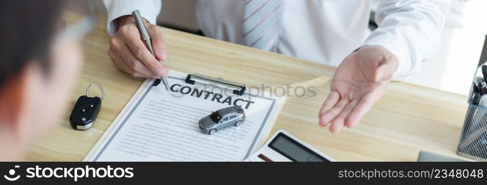 Insurance concept the car salesman describing the agreement on car contract to his customer.