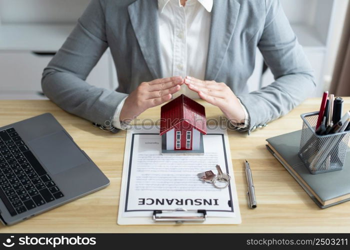 Insurance concept the property dealer presenting the modern model of house to the client.