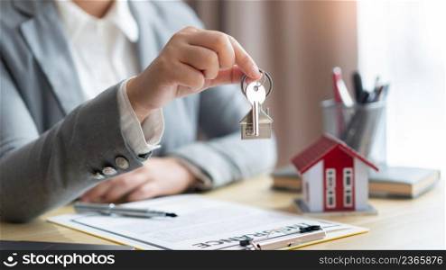 Insurance concept the real estate representative giving a house key to his client after signing the contract.
