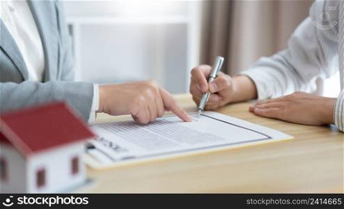 Insurance concept the selling broker reading the contract of purchasing house to his customer.
