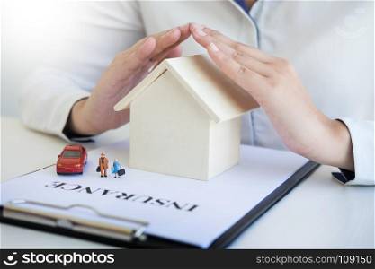 insurance with hands over a house, a car and a family, Protection People concept