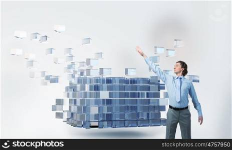 Integrating new technologies. Businessman reaching hand to touch 3D rendering cube figure