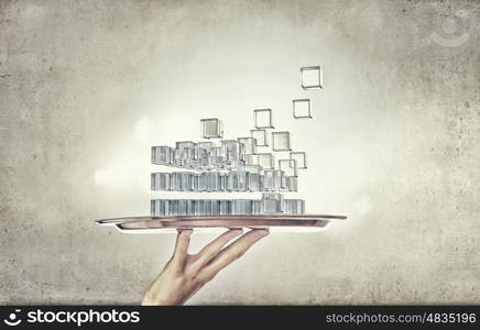 Integration of new technologies. Hand holding metal tray with digital cube figure