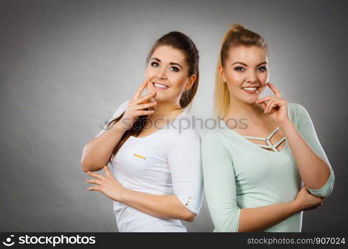 Intellectual expressions, being focused concept. Two attractive women thinking about something. Grey background.. Two women thinking about something