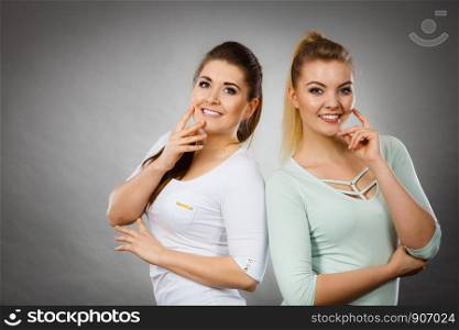Intellectual expressions, being focused concept. Two attractive women thinking about something. Grey background.. Two women thinking about something