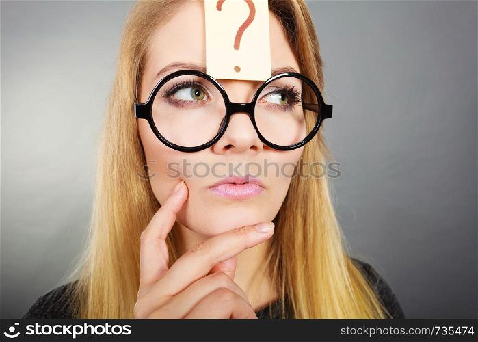 Intellectual expressions, being focused concept. Woman wearing weird nerd eyeglasses having question mark on forehead thinking about something. Woman having question mark on forehead thinking