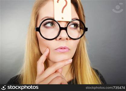Intellectual expressions, being focused concept. Woman wearing weird nerd eyeglasses having question mark on forehead thinking about something. Woman having question mark on forehead thinking