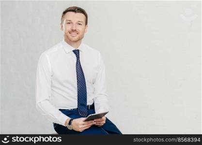 Intelligent lawyer in elegant clothes, holds digital tablet, spends free time in office, has pleasant smile on face, isolated over whte background with copy space for your advertising content
