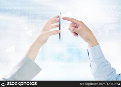 Interaction concept. Close up of human hands using one mobile phone at the same time