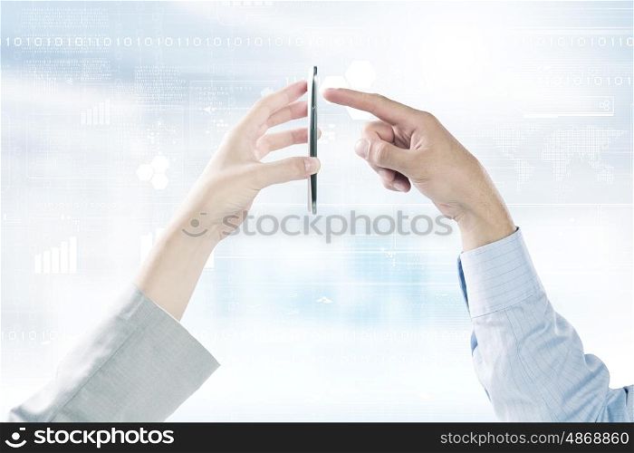 Interaction concept. Close up of human hands using one mobile phone at the same time